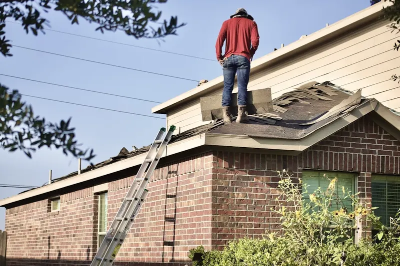 Professional roofer working on a residential roof in North Tabor